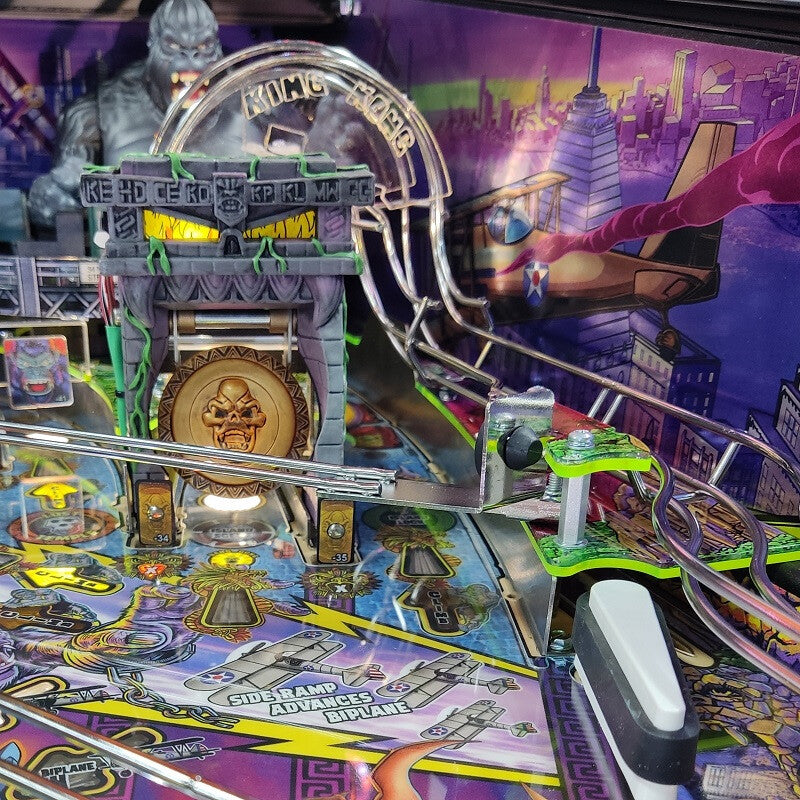 Close-up of a pinball machine with colorful artwork and mechanical components.