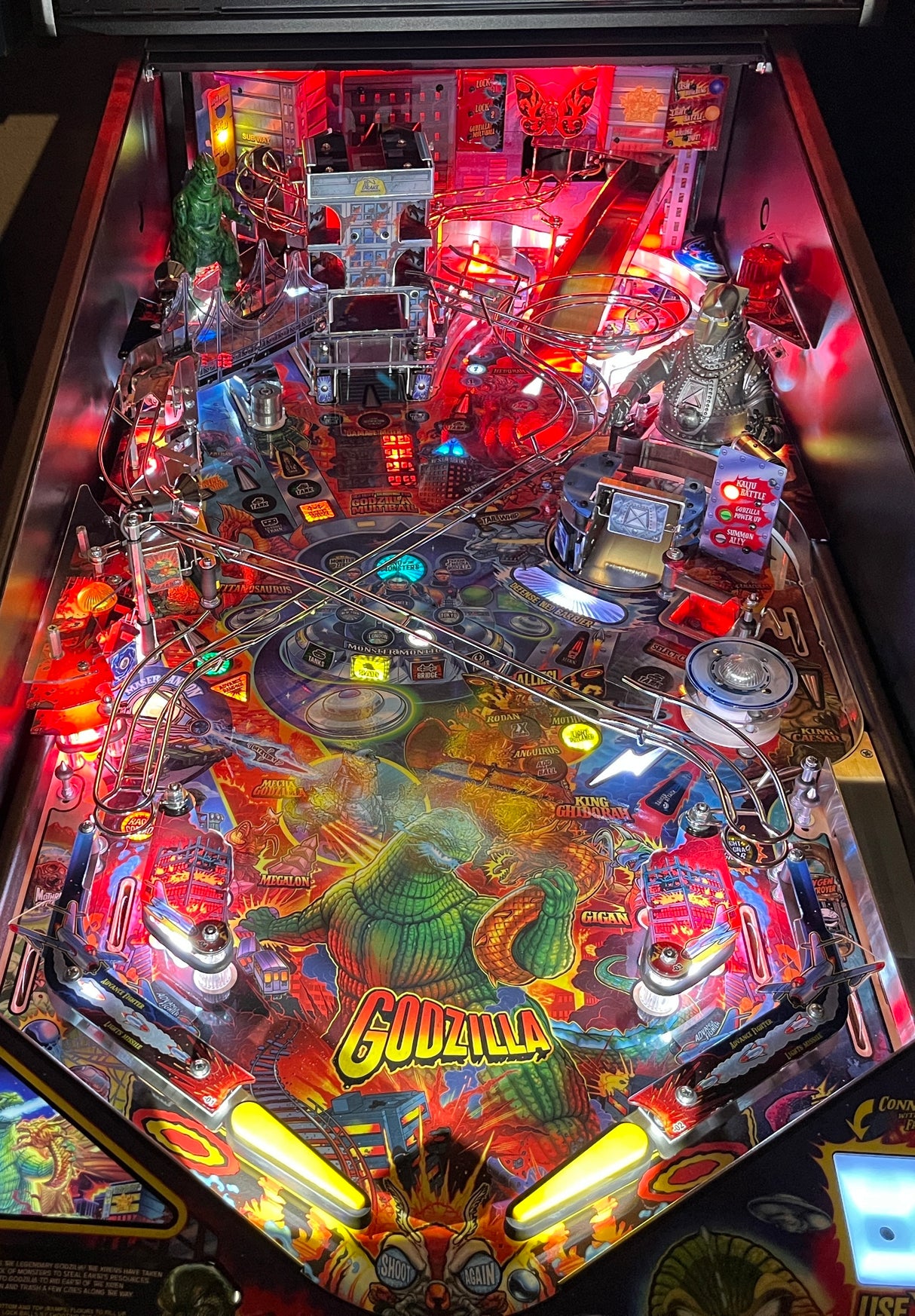 Pinball machine with 'Godzilla' theme featuring bright lights and detailed artwork.