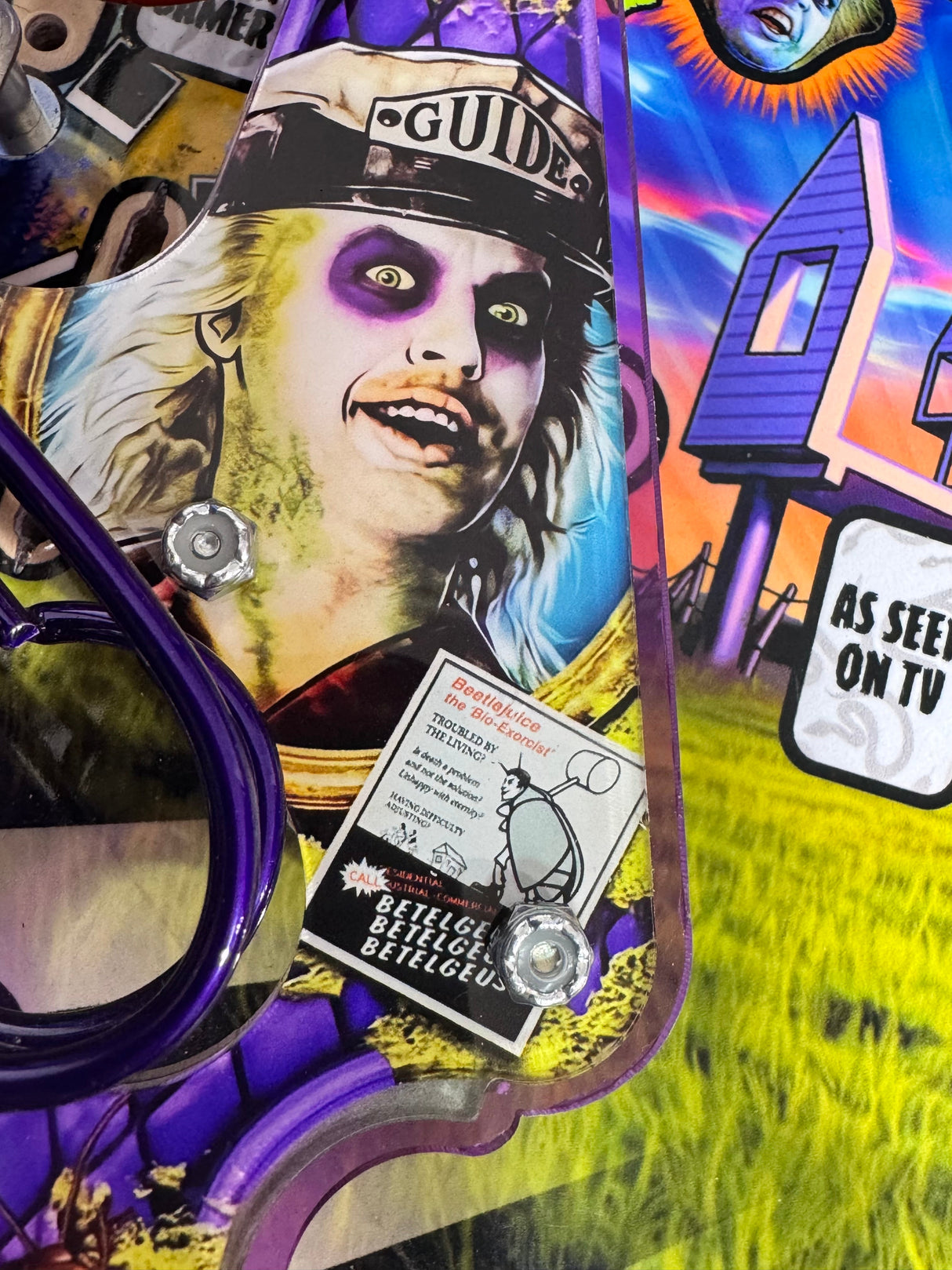 Close-up of installed left slingshot plastic showing Betelgeuse in a GUIDE hat with purple eye sockets.