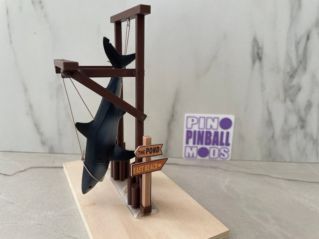 Hanging toy shark on a brown wooden like bracket with signs