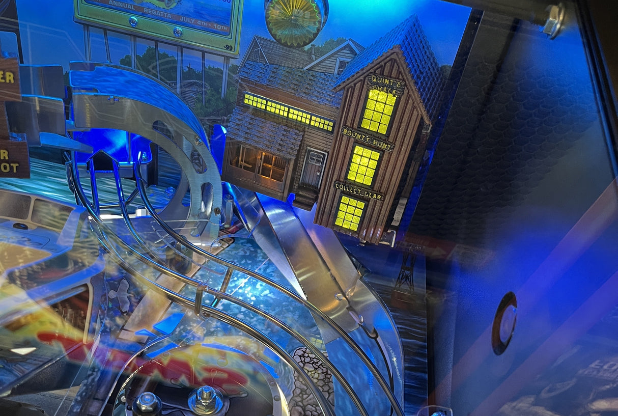 Close-up of a pinball machine with detailed artwork and lights.