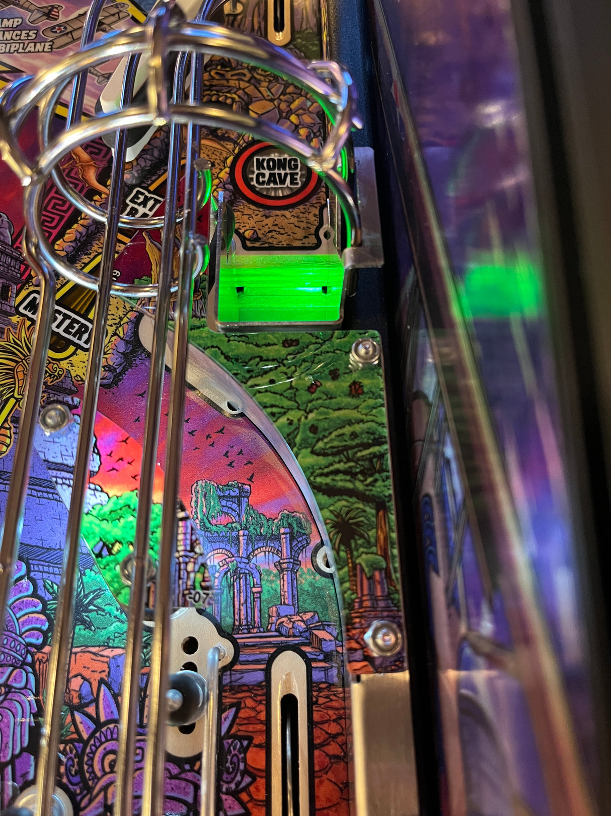Close-up of a pinball machine with colorful artwork and metal components.