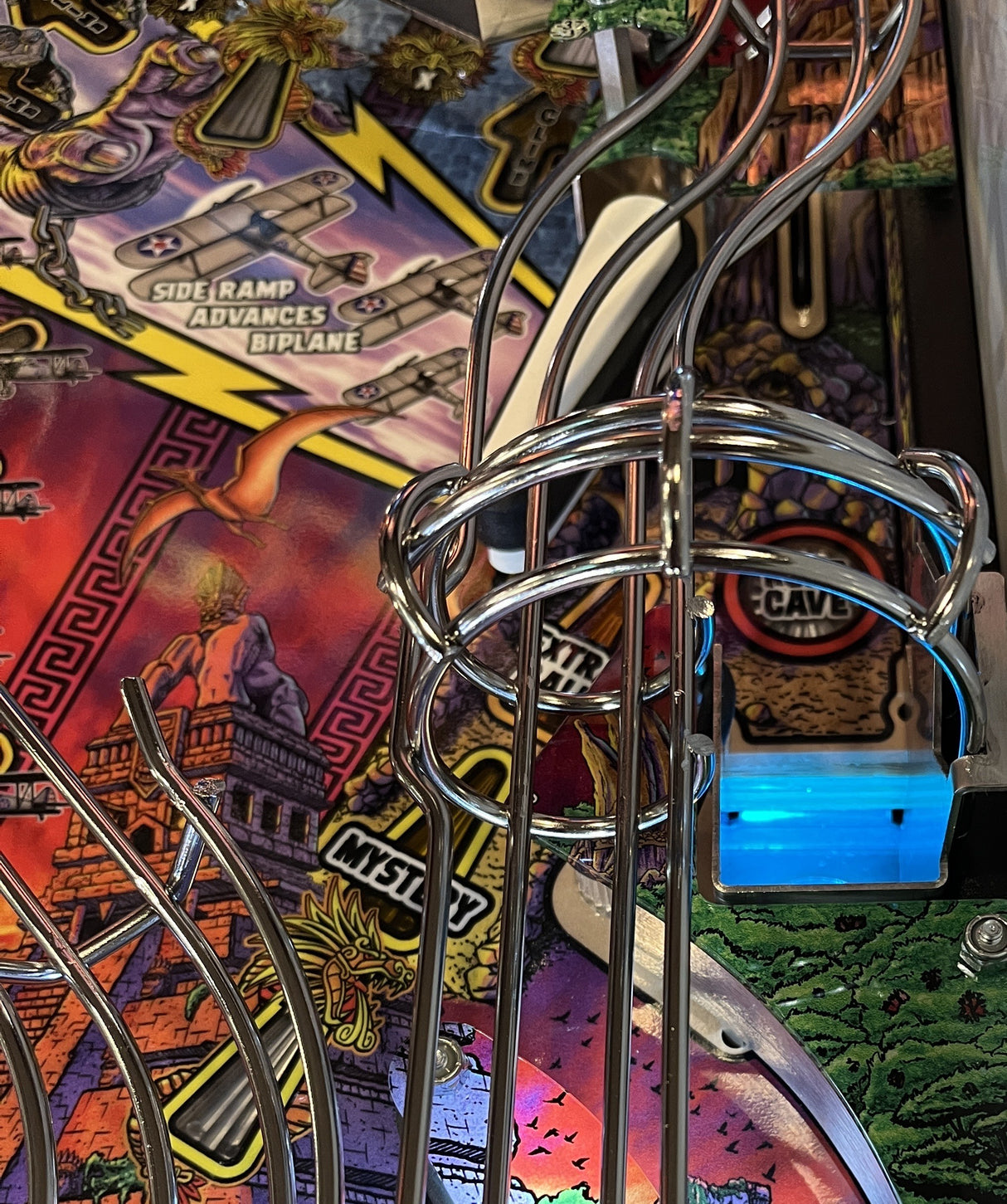 Close-up of a pinball machine with colorful artwork and metal components.