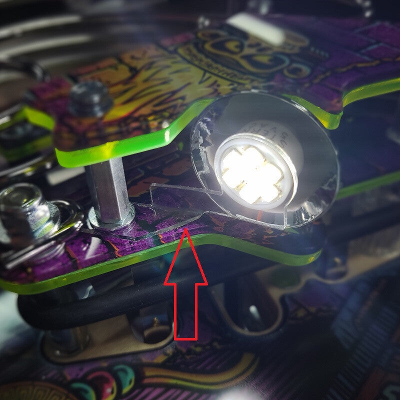 Close-up of a plastic holder with a light bulb attached, showing a red arrow pointing to the plastic.