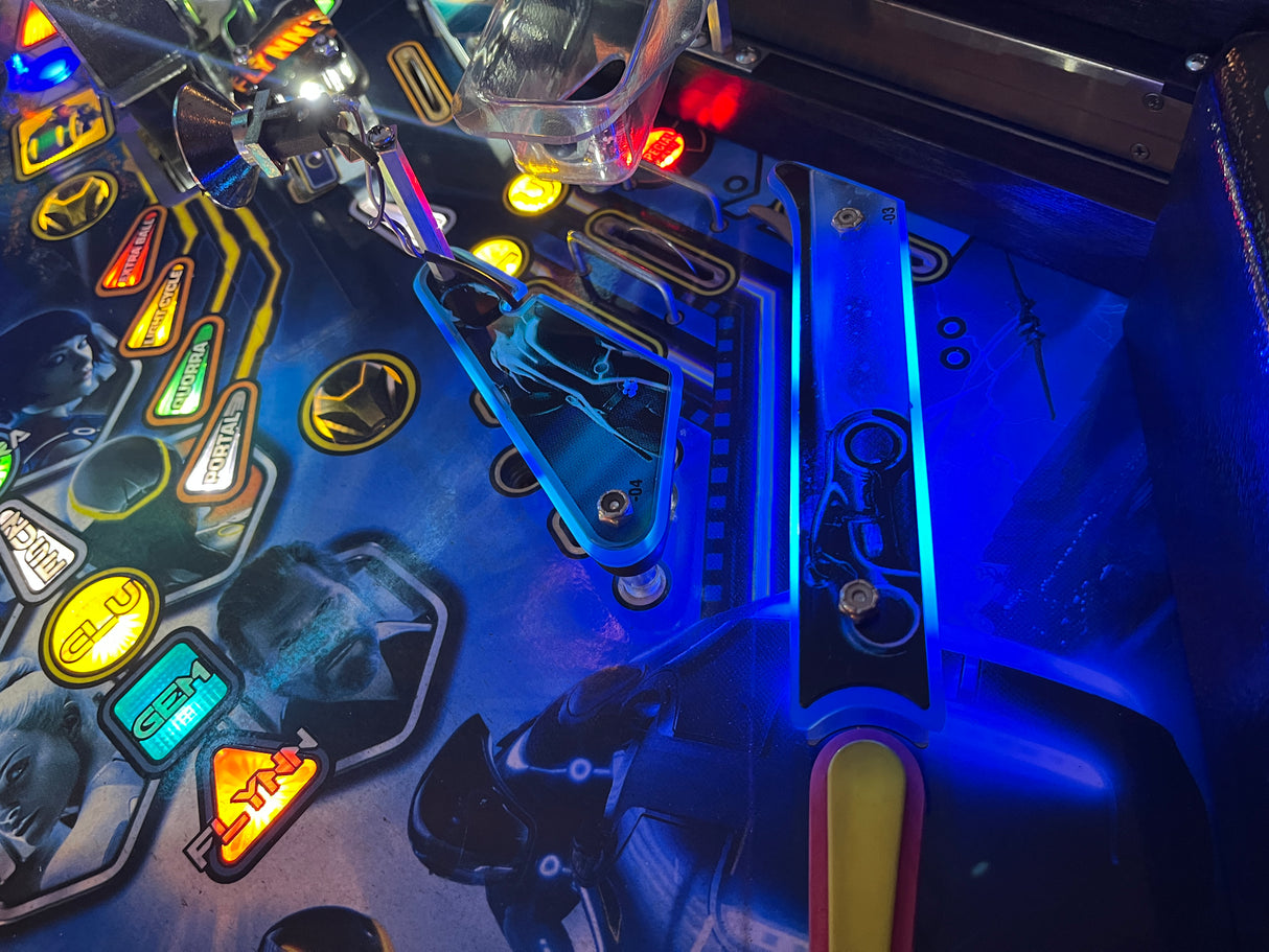 Close-up of a pinball machine with glowing lights and mechanical components.