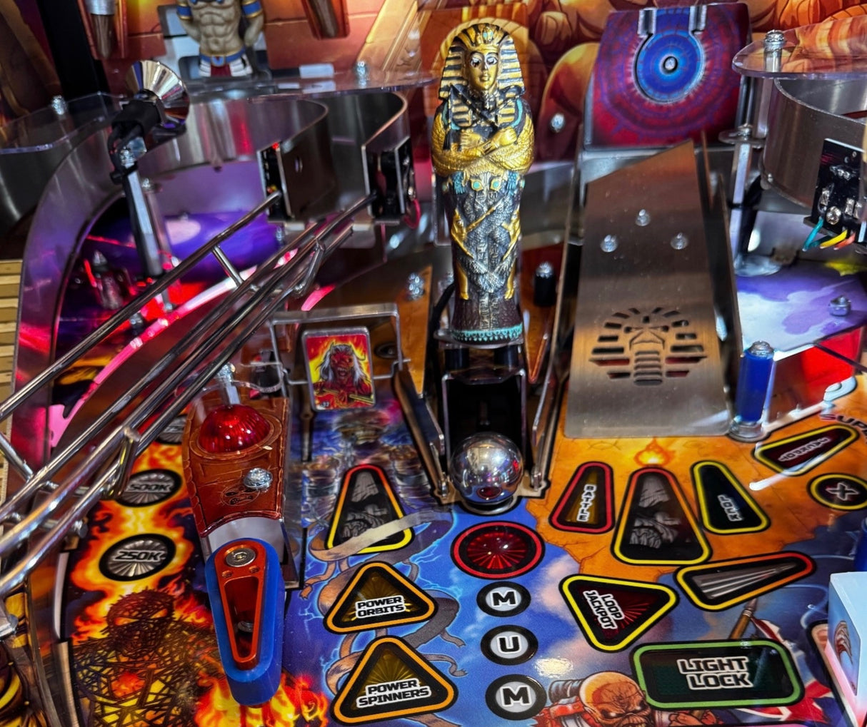 Close-up of a pinball machine with various components and artwork.