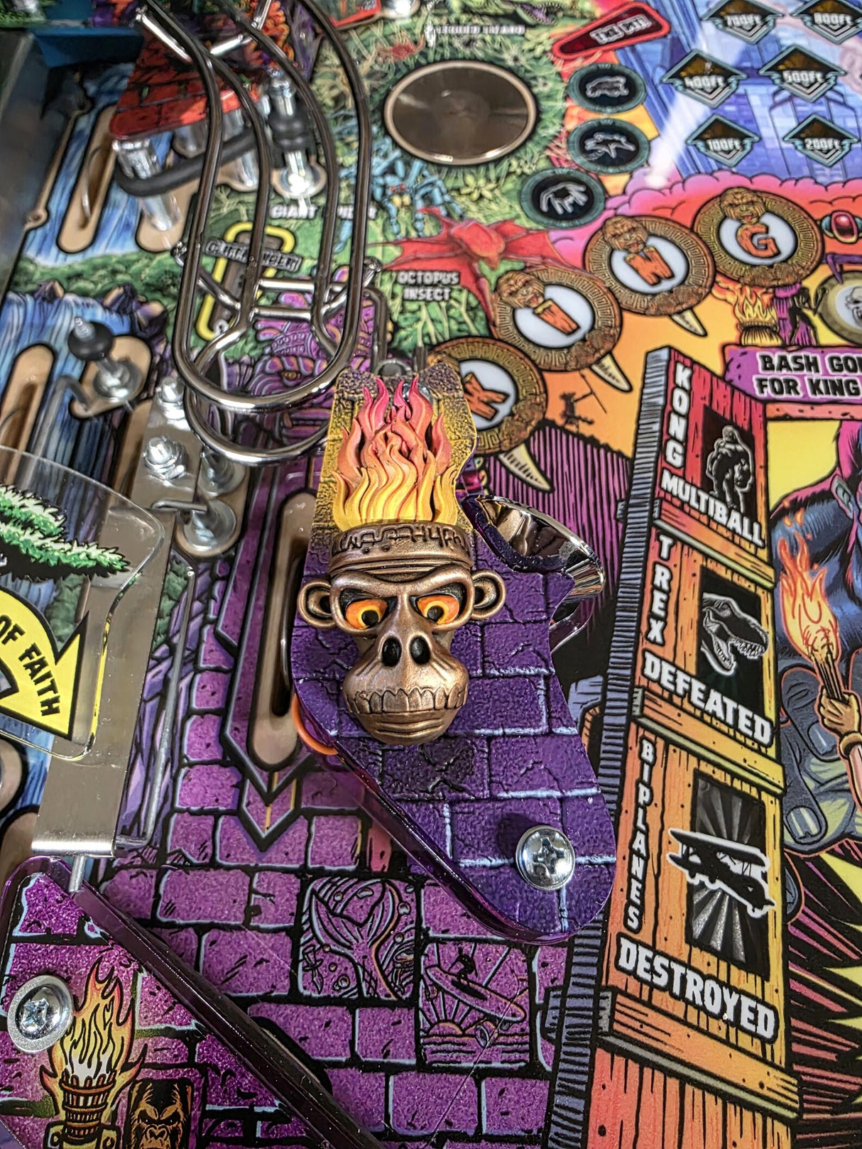 Close-up of a colorful pinball machine with various designs and text.