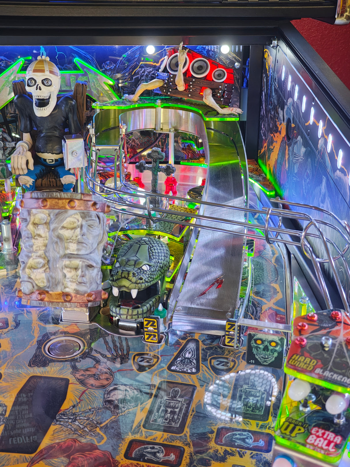 Close-up of a colorful pinball machine with various components and artwork.