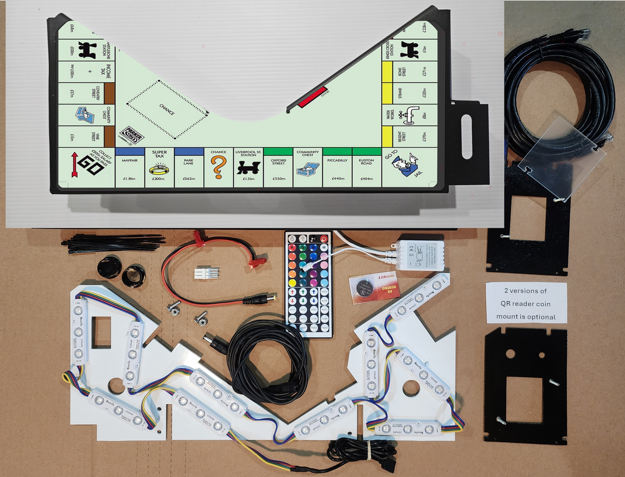 Monopoly pinball apron replacement with game board artwork and electronic components on a cardboard surface