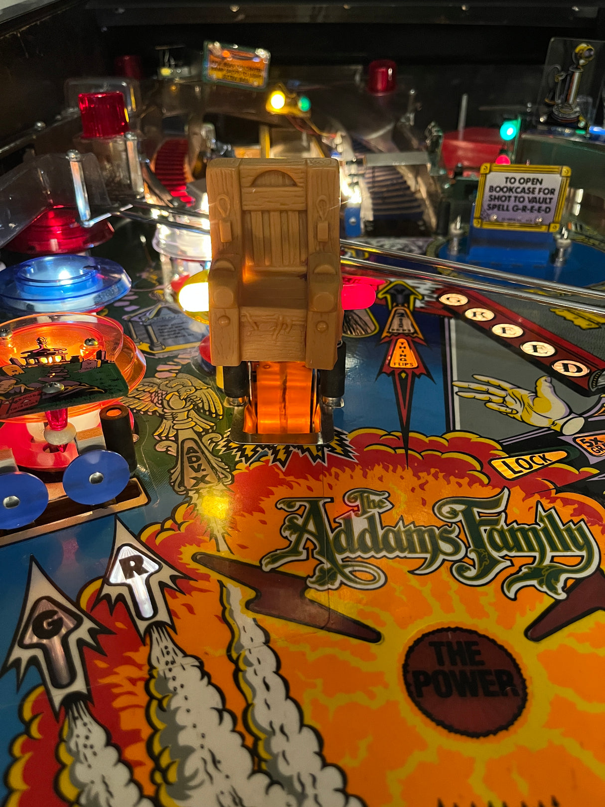 Pinball machine with 'Addams Family' theme, featuring colorful artwork and game components.