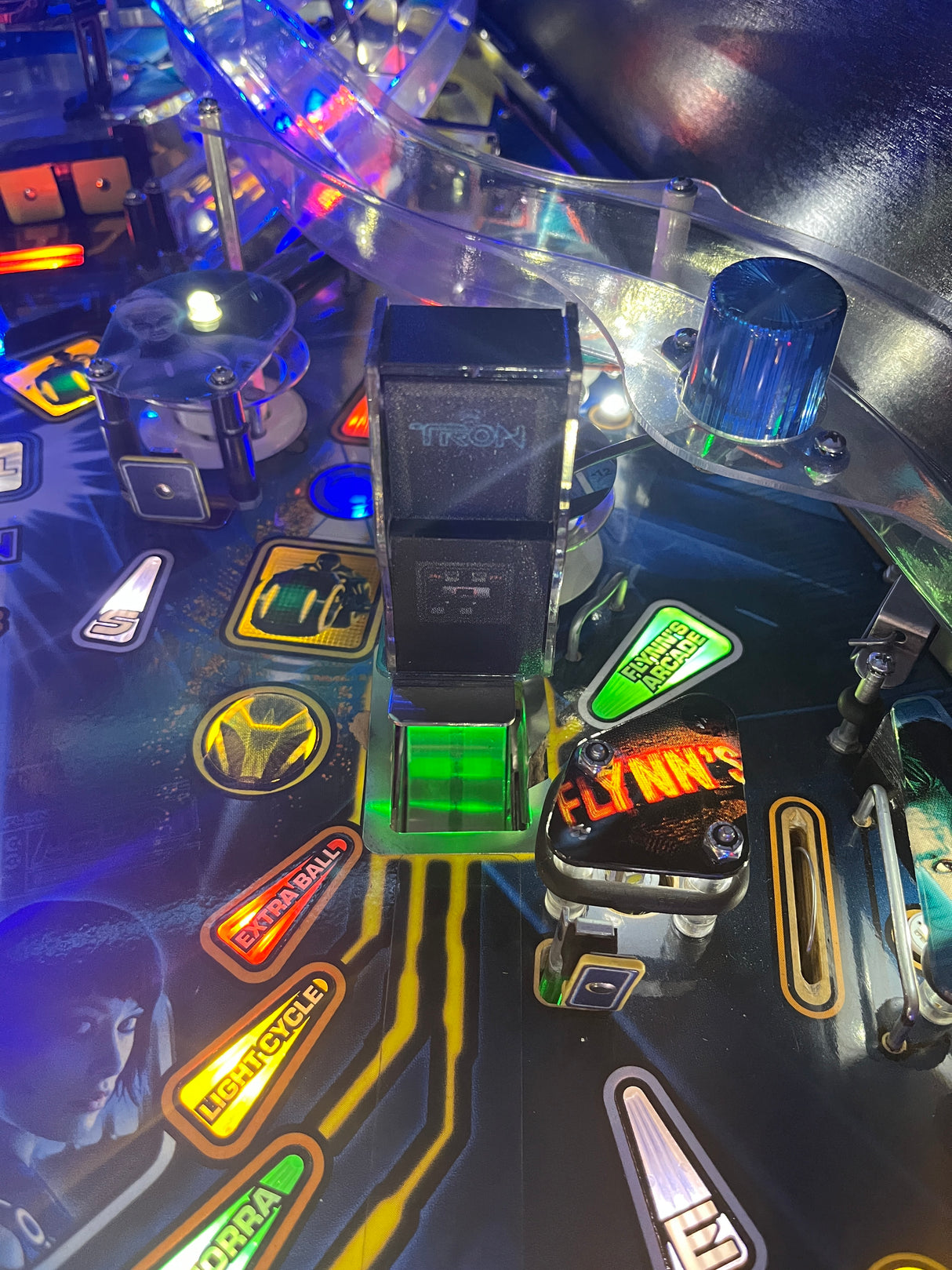 Close-up of a pinball machine with colorful lights and symbols