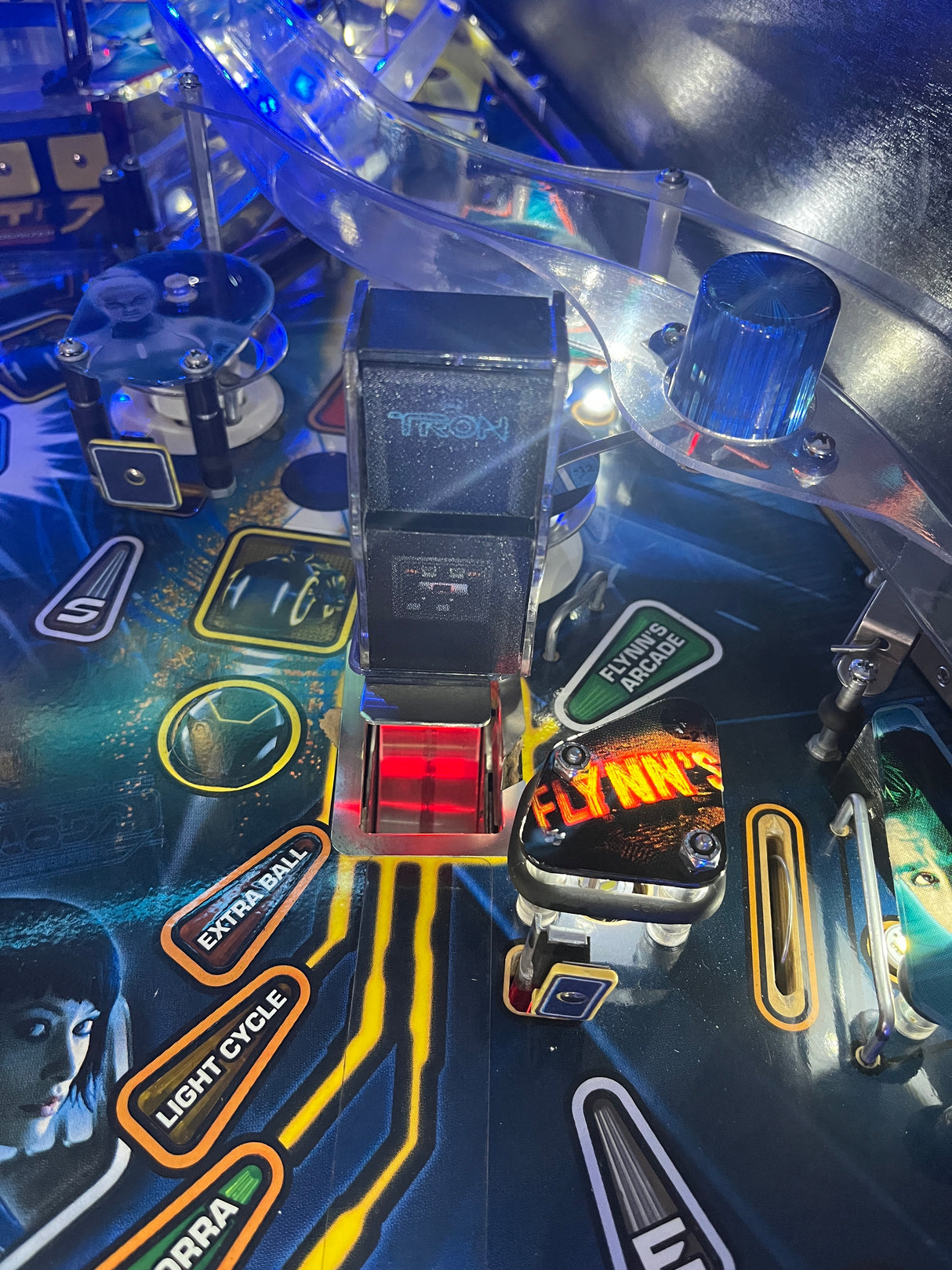Close-up of a pinball machine with various buttons and lights.