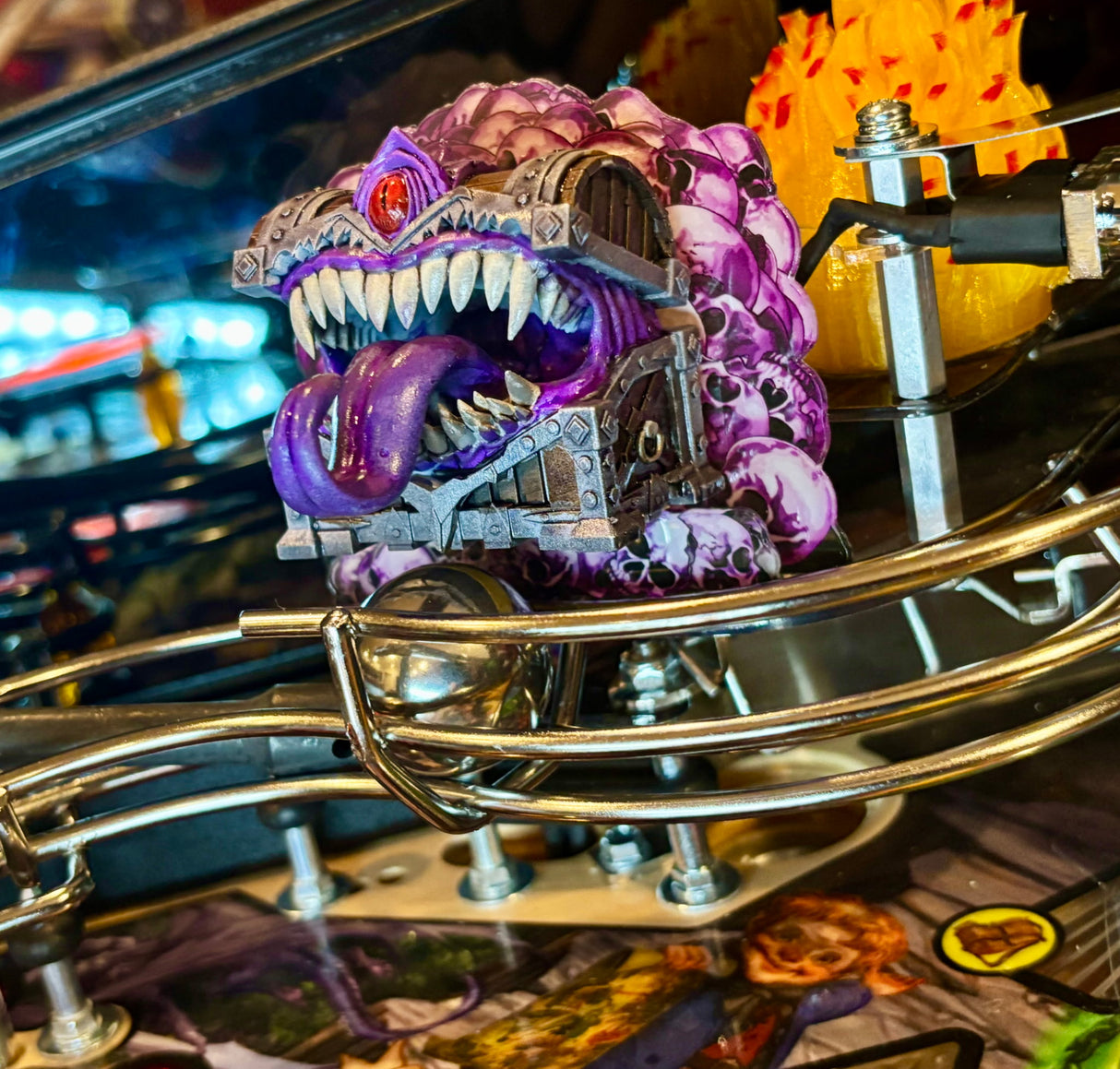 pinball machine with brightly colored  toy chest like a monster