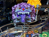 Toy figure of a purple creature with sharp teeth on a metallic stand.