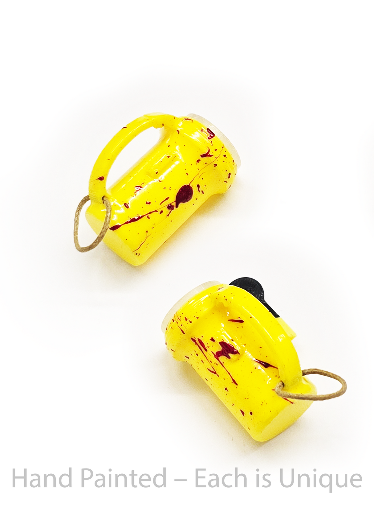 Two yellow hand-painted flashlight toys with red splashes on a white background.