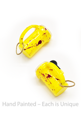 Two yellow hand-painted flashlight toys with red splashes on a white background.