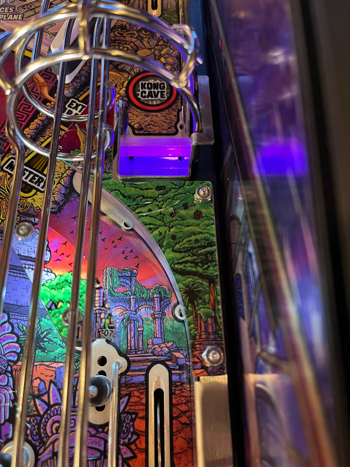 Close-up of a pinball machine with colorful artwork and 'Kong's Cave' label.