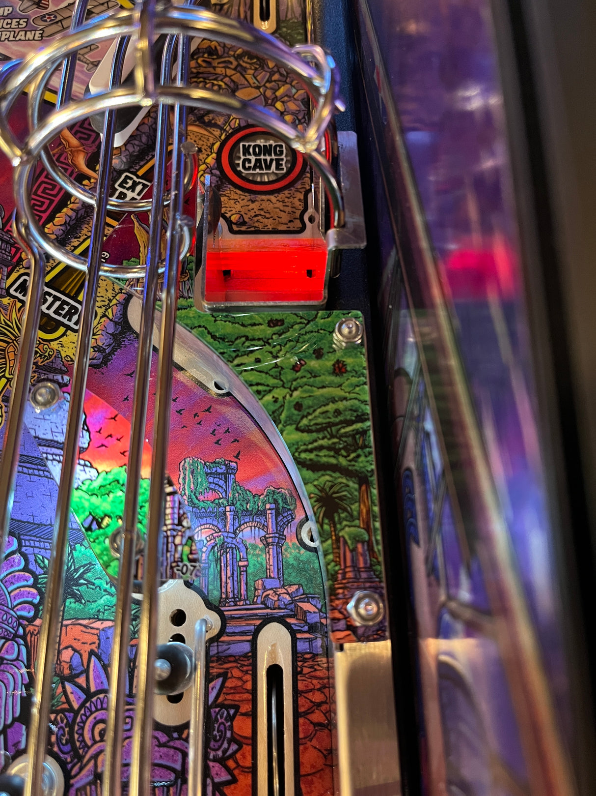 Close-up of a pinball machine with colorful artwork and 'Kong's Cave' label.