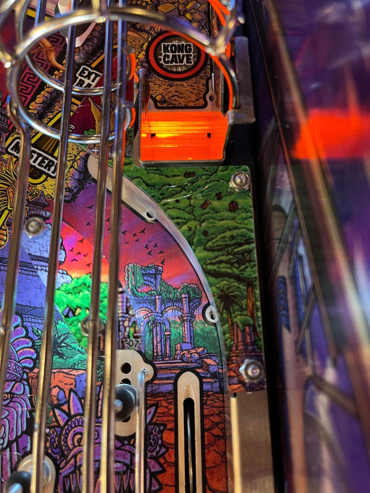 Close-up of a pinball machine with colorful artwork and 'Kong's Cave' label.