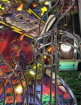Close-up of a pinball machine with colorful artwork and metal components.