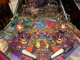Colorful pinball machine with various components and artwork on a dark background