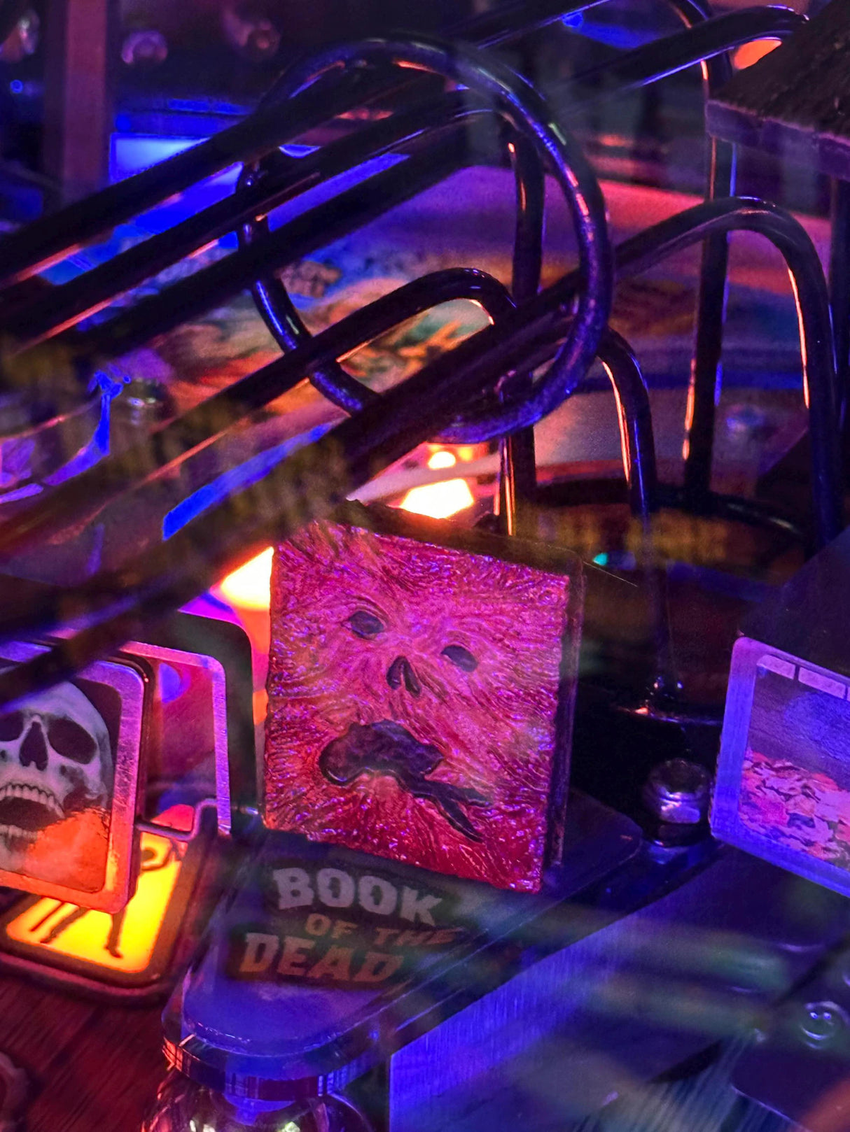 Close-up of a pinball machine with glowing marquee and colorful artwork.
