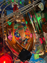 Close-up of a colorful pinball machine with various elements and artwork.