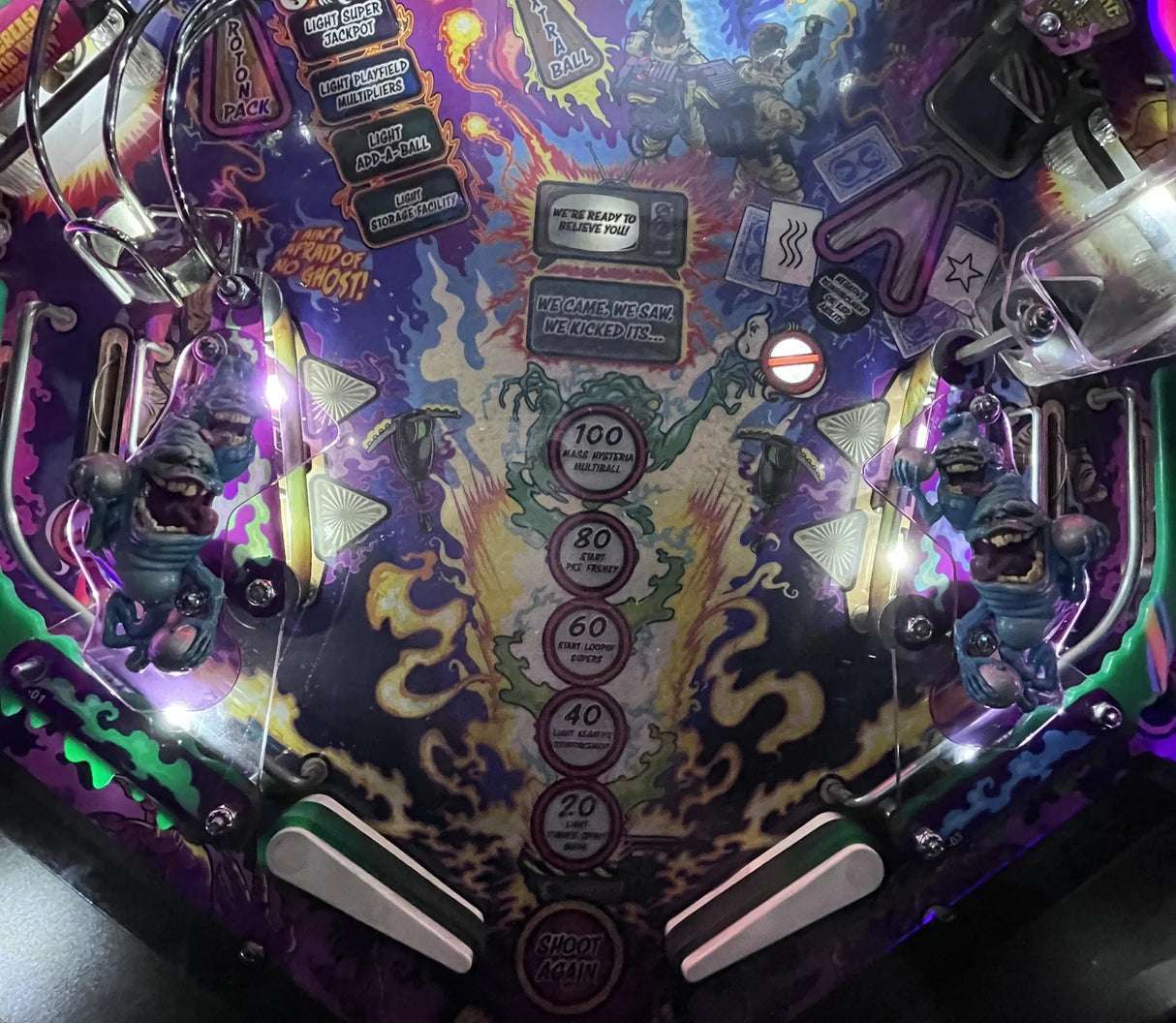 Close-up of a colorful pinball machine with various components and lights.