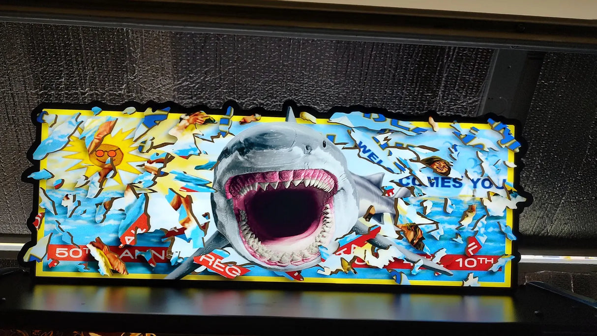 Shark-themed acrylic topperwith colorful design on a dark surface