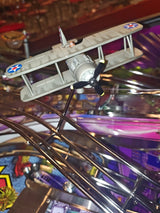 Toy airplane hanging on a metallic surface with a colorful, blurred background