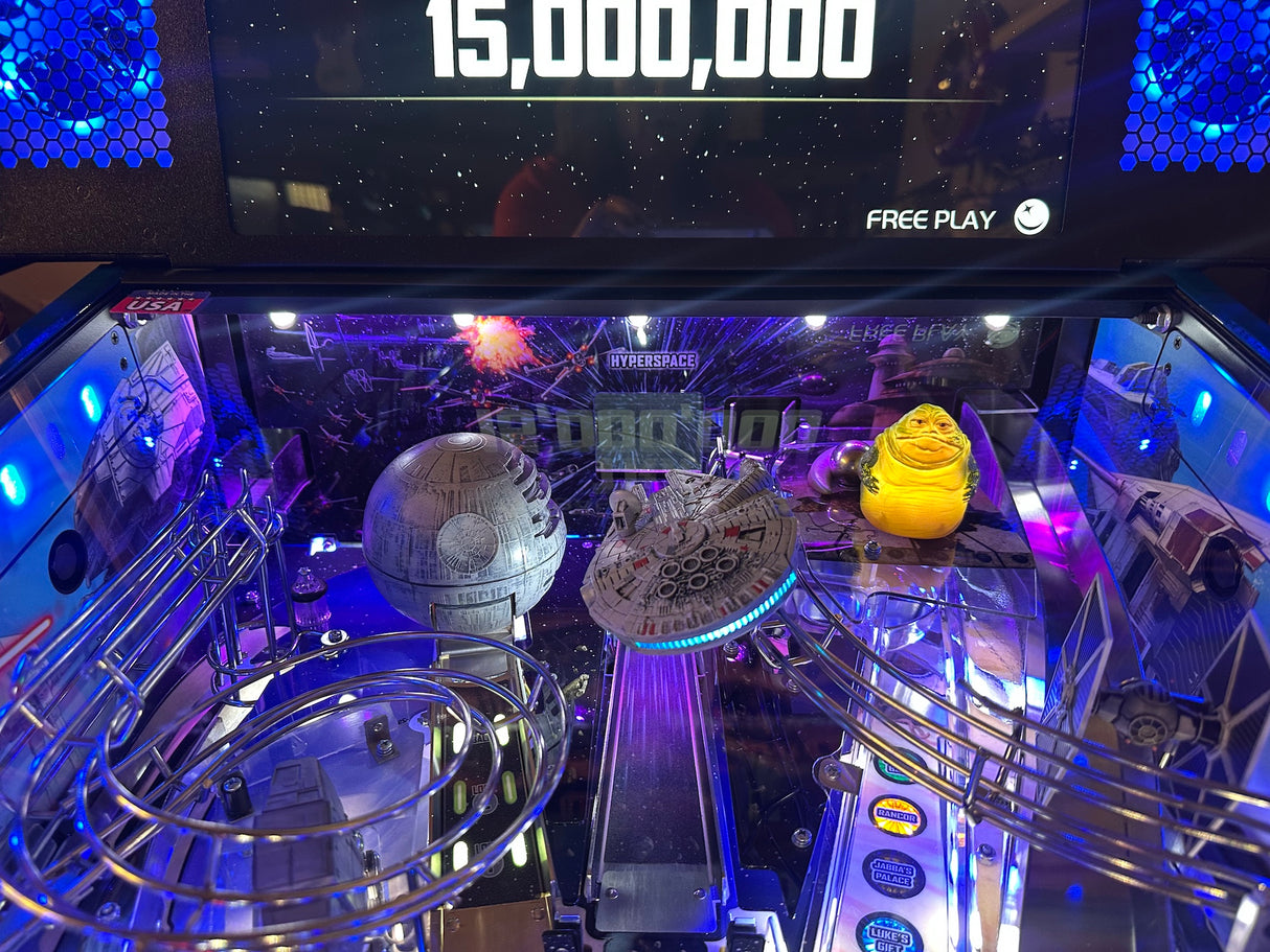 Pinball machine with Star Wars-themed figures and a digital display showing '15,000,000' in the background.